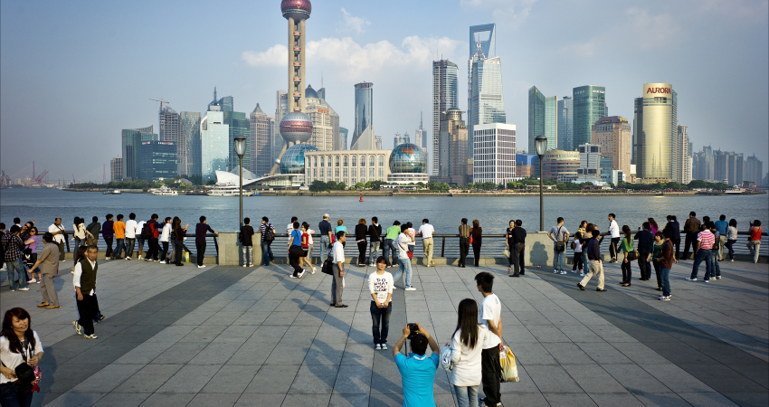 Toeristen poseren voorde skyline van Shanghai