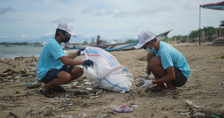 Vrijwilligers van OCG saving the ocean rapen afval op van het strand